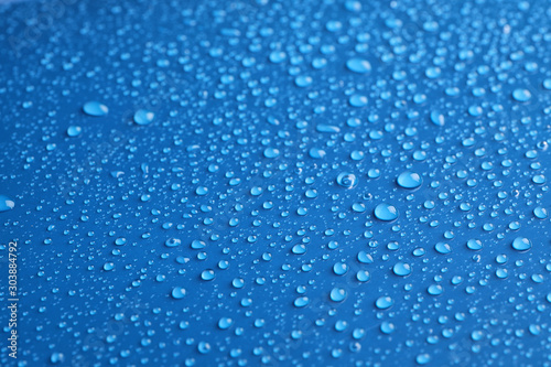 Water drops on blue background, closeup view