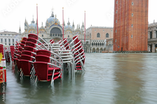 Red submerged chairs in Saint Mark Square full of water in Venic photo