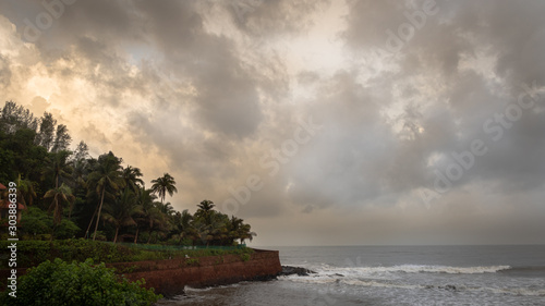 Landscape of the seashores of Goa with sky, clouds and palm trees during monsoon