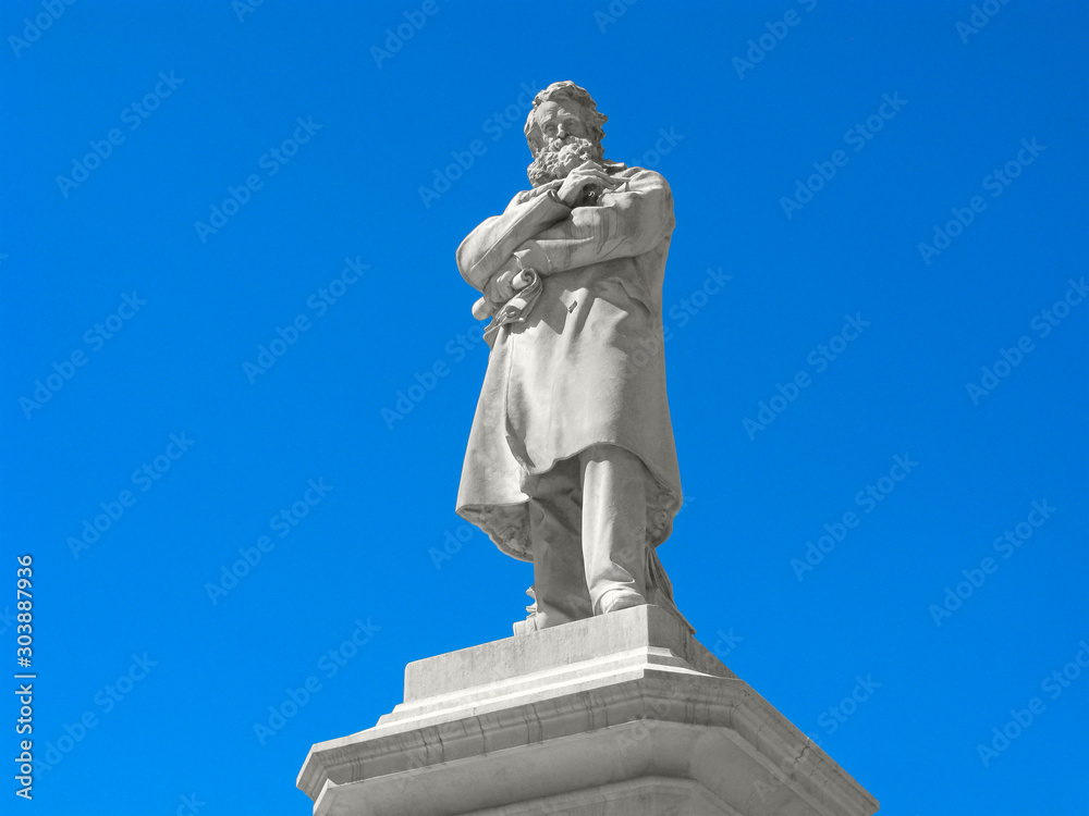 Fototapeta premium Sculpture of Niccolo Tommaseo is isolated on clear blue sky. Venice, Italy. Niccolo Tommaseo is Italian writer, philologist, linguist, journalist and politician.