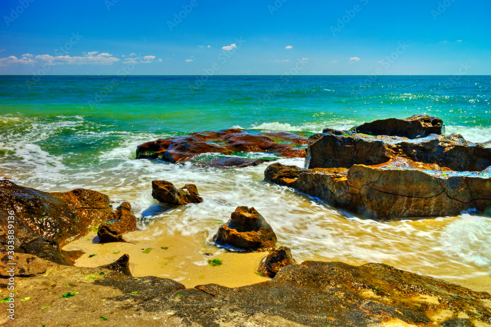 Beautiful landscape with rocks and sea waves on a sunny beach