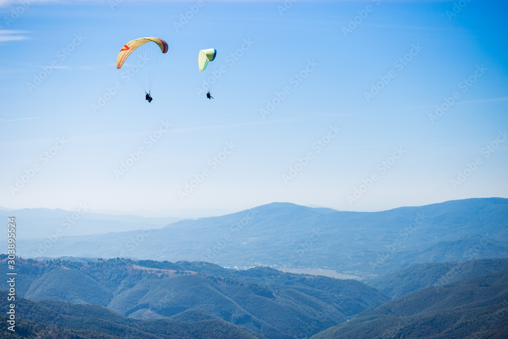 Paragliding group in air sport on top of a mountain. The whole world is in sight. Like a bird, out of gravity Paragliding group in air sport on top of a mountain. The whole world is in sight. Like a bird, out of gravity