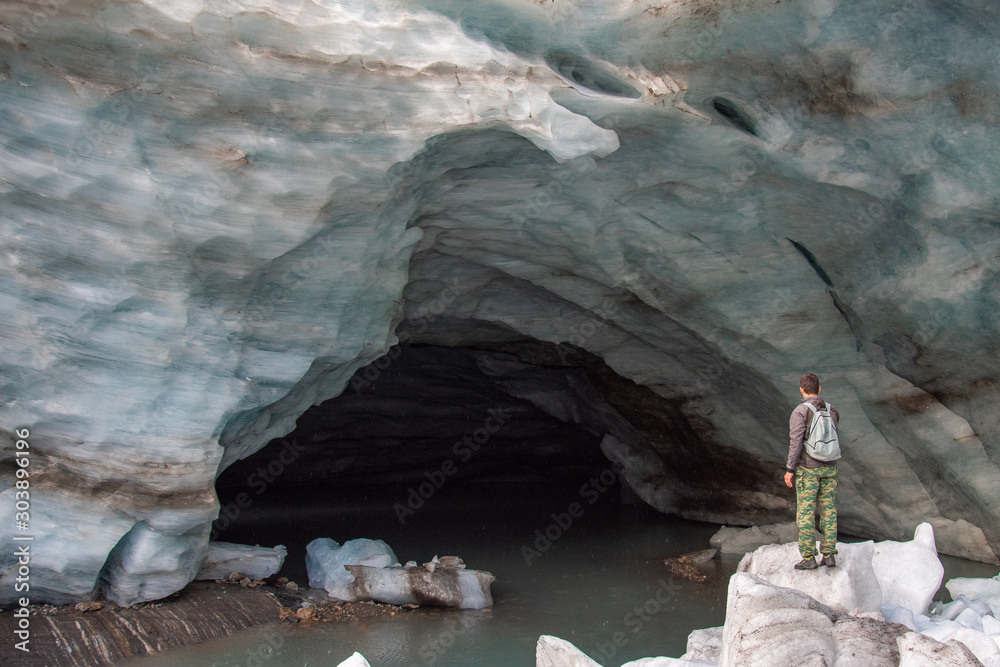 Φωτογραφία A man stands in the snow in front of entrance to the snow cave of the Alibek mou