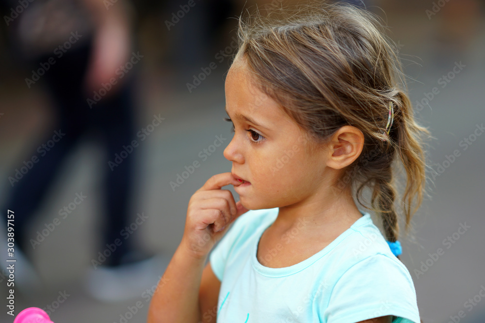 Fototapeta premium Portrait of 4 year old girl on the blurred background of a shopping street in Sofia