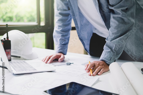 Architect or engineer working in office with blueprints,engineer inspection in workplace for architectural plan,sketching a construction project ,selective focus,Business construction concept.