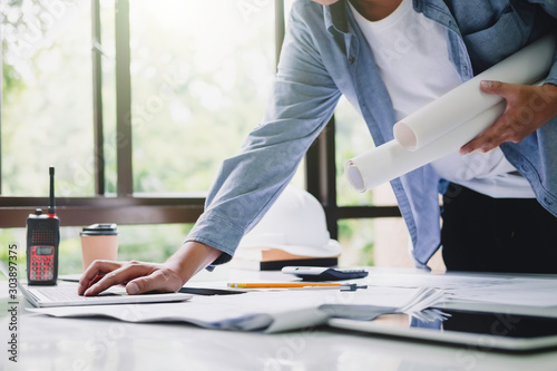 Architect or engineer working in office with blueprints,engineer inspection in workplace for architectural plan,sketching a construction project ,selective focus,Business construction concept.