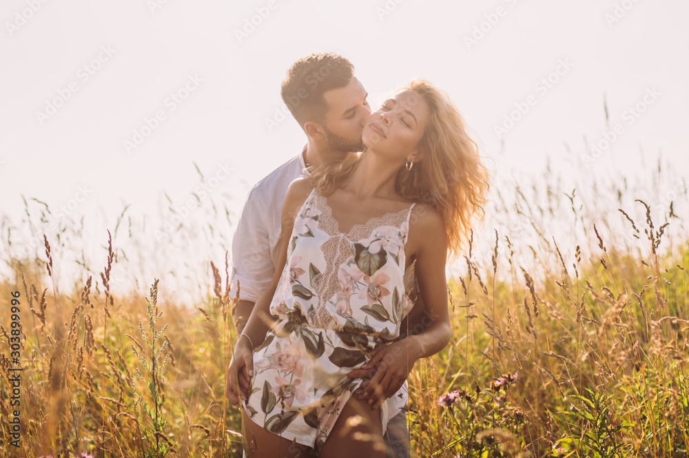 Young man hugging and kissing his girlfriend in the field Young man hugging and kissing his girlfriend in the field