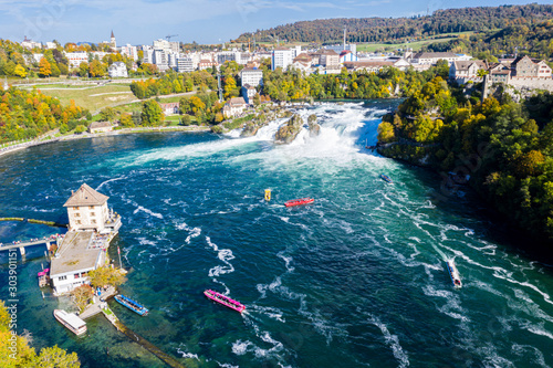 Rhine Falls (Rheinfall), Switzerland panoramic aerial view. Tourists boats in waterfall. Cliff-top Schloss Laufen castle, Laufen-Uhwiesen. View of Neuhausen am Rheinfall town in the background 
