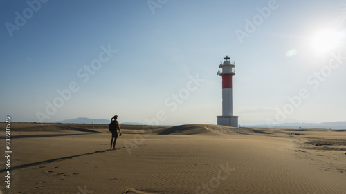 boy looking at a lighthouse in a desert