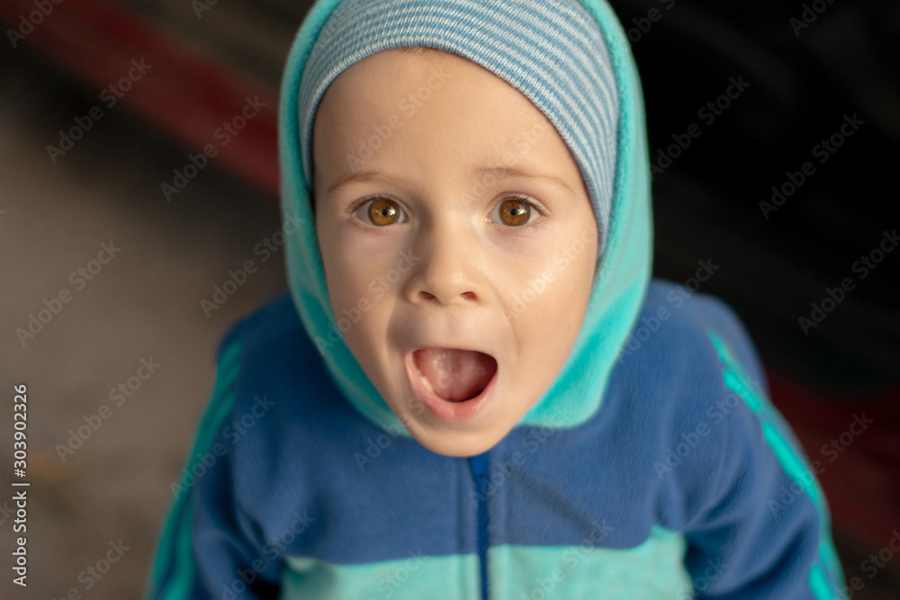 A boy with a surprised expression. The little kid opened his mouth in surprise. The screaming face of a child A boy with a surprised expression. The little kid opened his mouth in surprise. The screaming face of a child