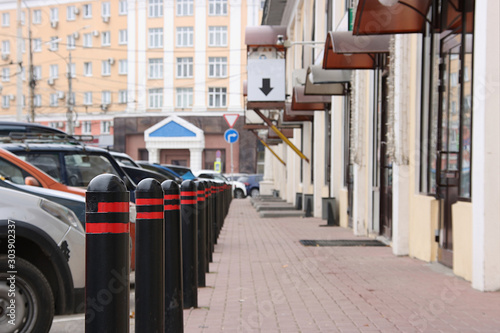 Black pillars fencing car parking spaces from the sidewalk © MIKHAIL BATURITSKII	