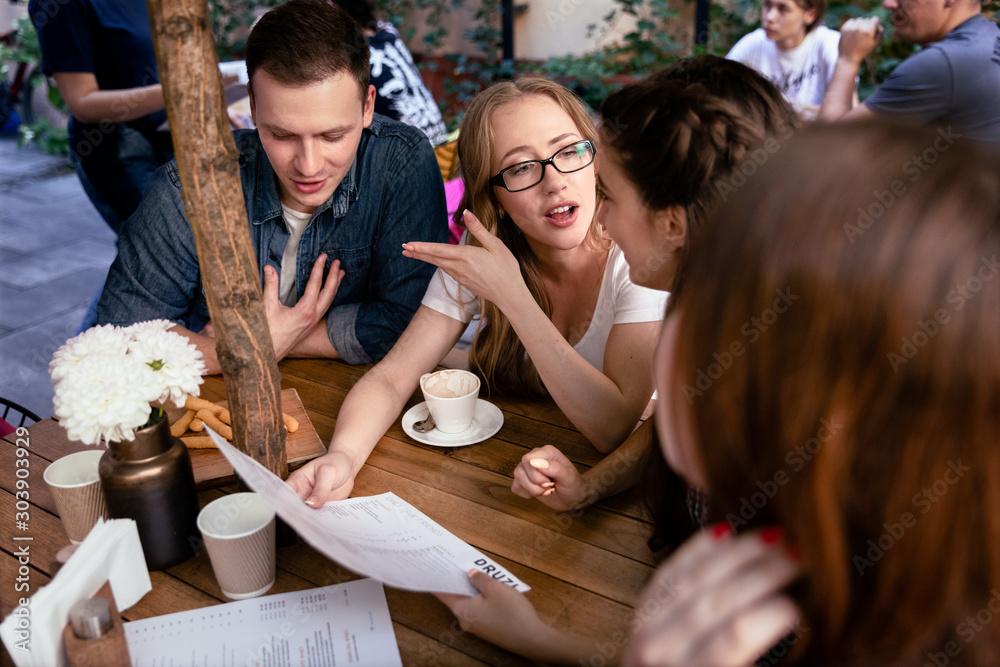 Φωτογραφία Informal brainstorm of a young team at the cosy restaurant and ordering food