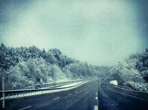 Germany, Bavaria, highway with rare traffic under snowstorm in winter