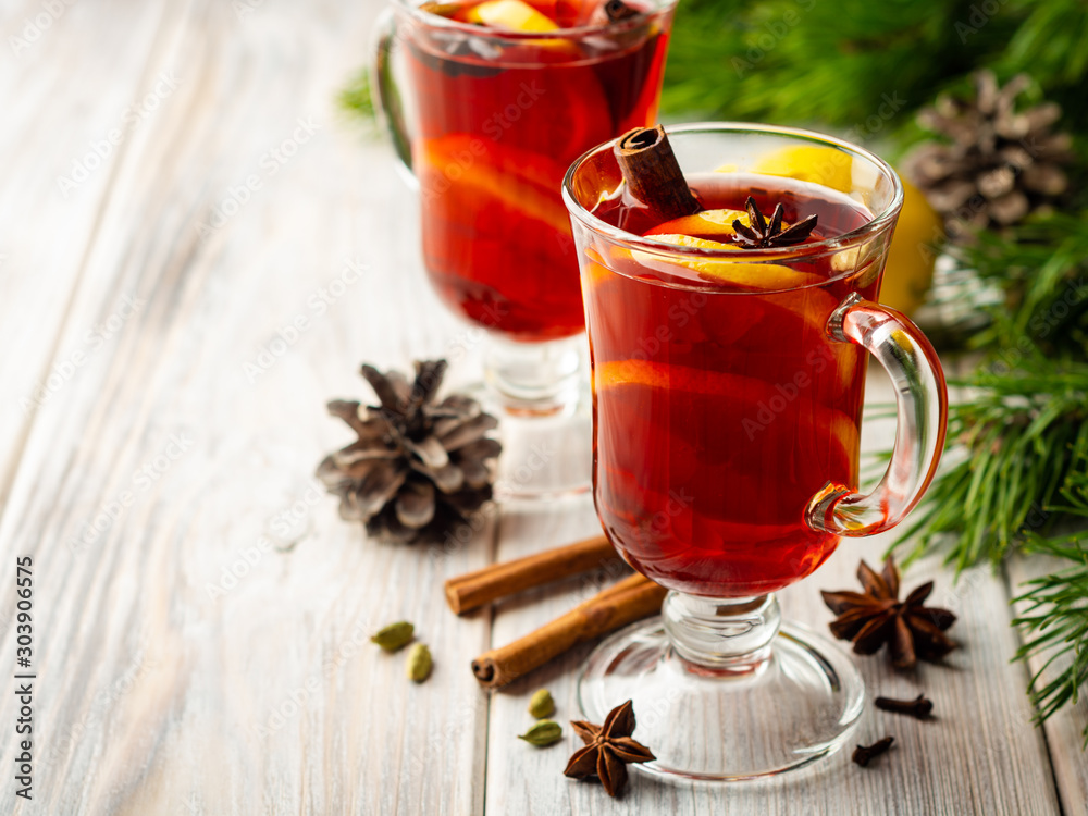 Christmas mulled wine with spices and lemon on wooden rustic background. Selective focus. Christmas mulled wine with spices and lemon on wooden rustic background. Selective focus.