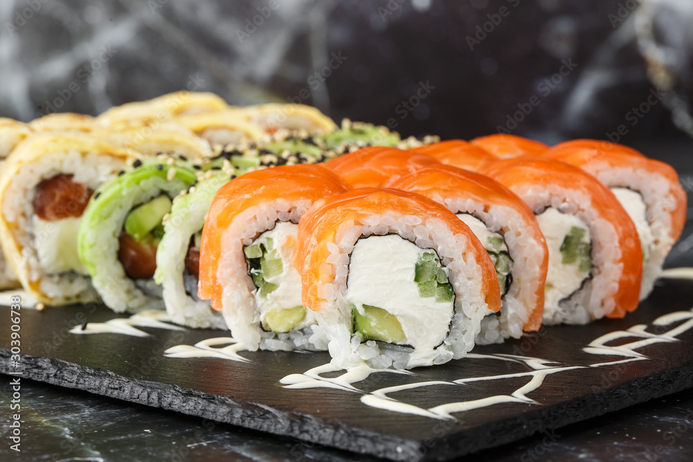 Various kinds of sushi served on black marble background. Sushi menu for Japanese food. Japanese sushi set. Rolls with tuna, salmon, shrimp, crab, caviar and avocado. Horizontal photo. Various kinds of sushi served on black marble background. Sushi menu for Japanese food. Japanese sushi set. Rolls with tuna, salmon, shrimp, crab, caviar and avocado. Horizontal photo.