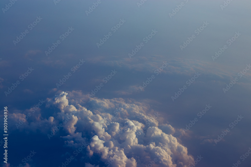 Fototapeta premium Aerial view sunset sky above clouds with dramatic light. View from airplane
