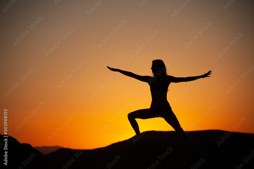 Yoga woman silhouette in the desert sunset. 