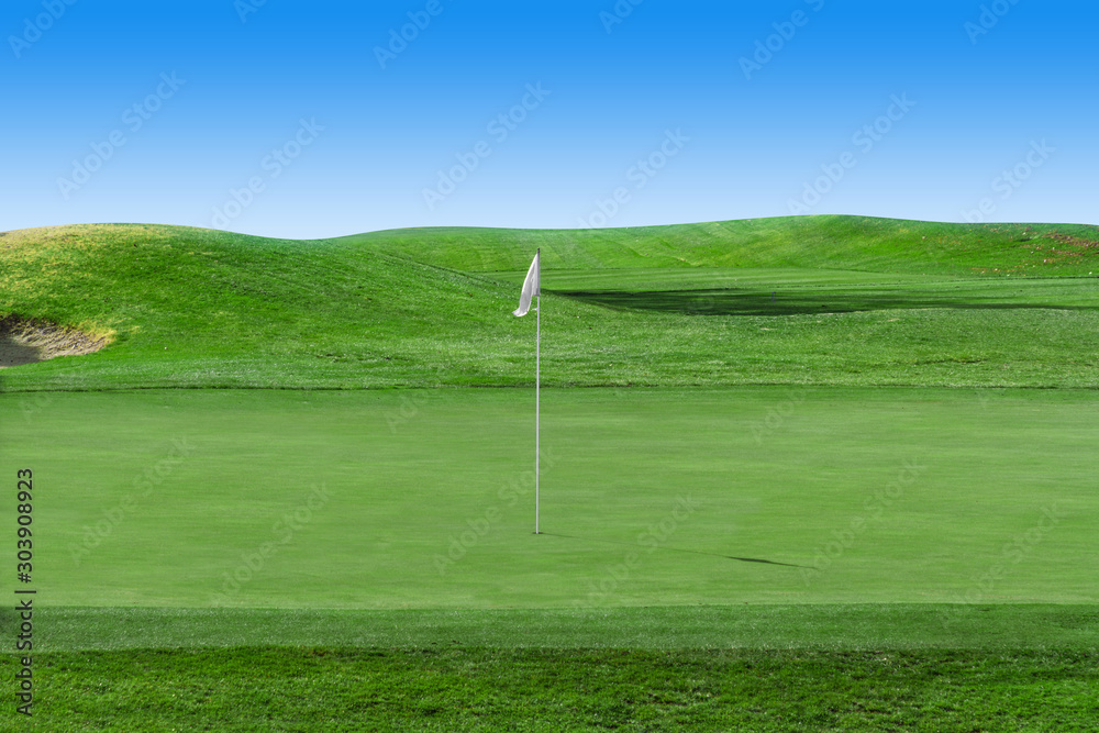 White flag on a golf course with blue sky White flag on a golf course with blue sky