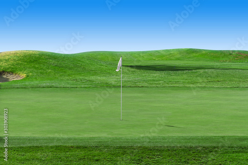 White flag on a golf course with blue sky