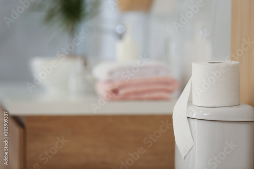 Paper roll on tank of toilet bowl in bathroom  space for text