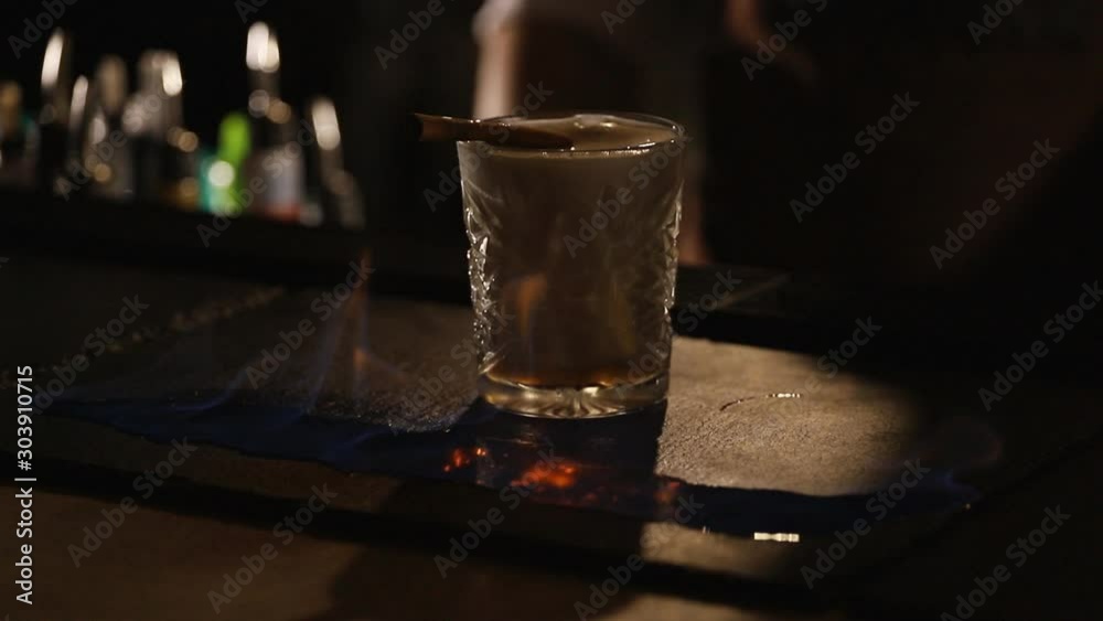 Bartender sets fire to cocktail, burning cinnamon in alcohol drink, barman makes drink.slow motion Bartender sets fire to cocktail, burning cinnamon in alcohol drink, barman makes drink.slow motion