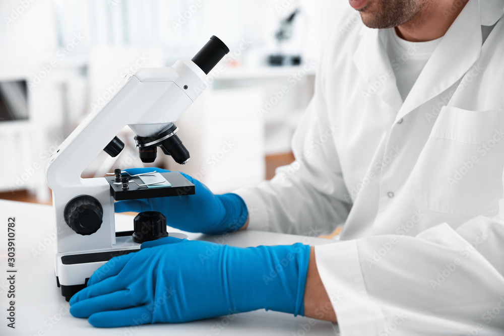 Scientist with modern microscope at table, closeup. Medical research Scientist with modern microscope at table, closeup. Medical research
