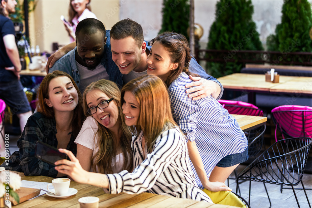 Φωτογραφία Informal meeting of best friends in the cosy cafe and taking selfie photo on the