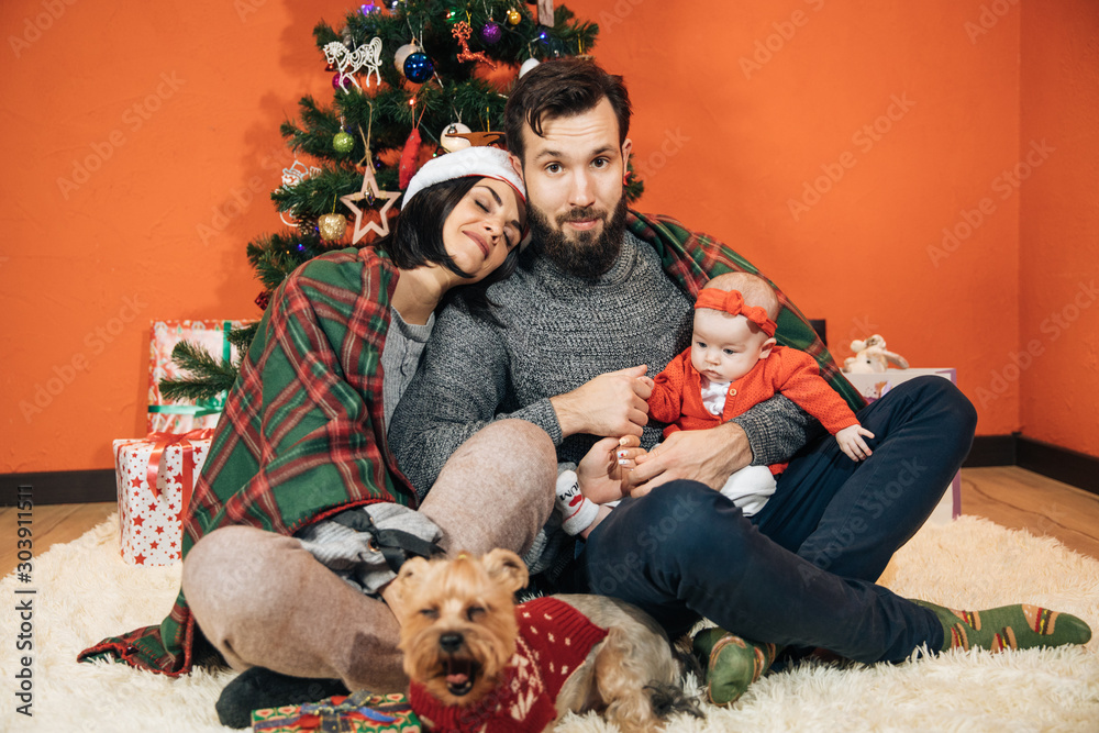 Φωτογραφία young family with a child near the Christmas tree, mom dad and their newborn dau