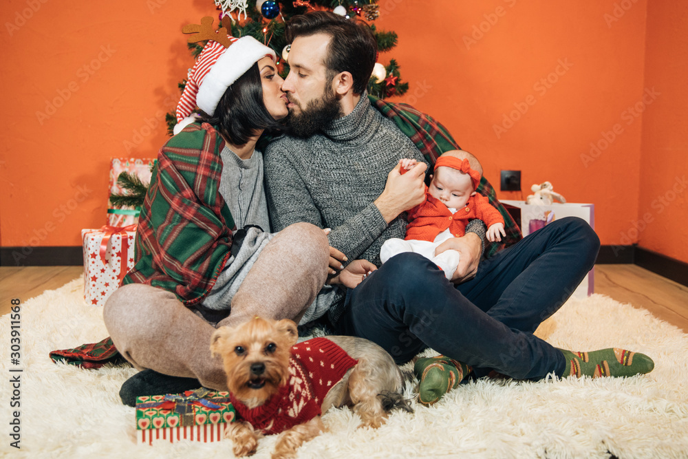 Φωτογραφία young family with a child near the Christmas tree, mom dad and their newborn dau
