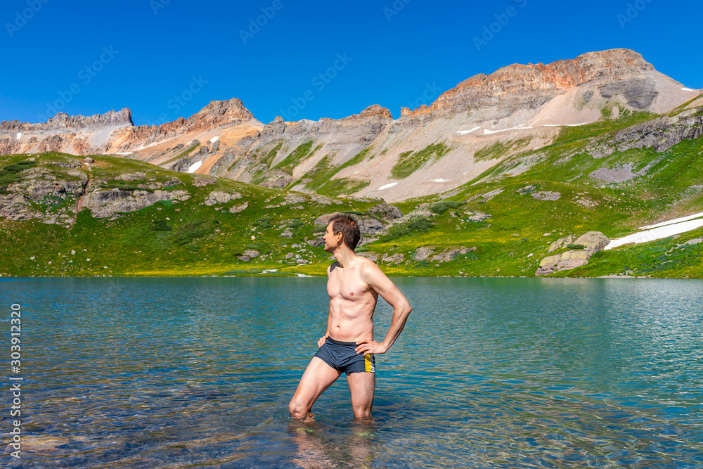 Φωτογραφία Young fit man standing in cold colorful water of Ice Lake on famous trail in Sil