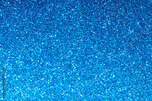 blue Sparkling Lights Festive background with texture. Abstract Christmas twinkled bright bokeh defocused and Falling stars. Winter Card or invitation	