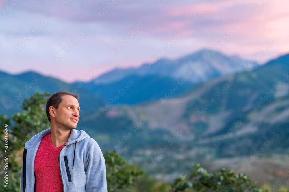 Aspen, Colorado rocky mountains colorful purple blue twilight sunset blurry background view and young man standing looking