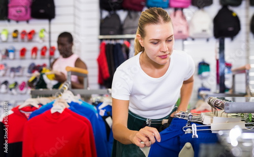 Female customer choosing sport clothes