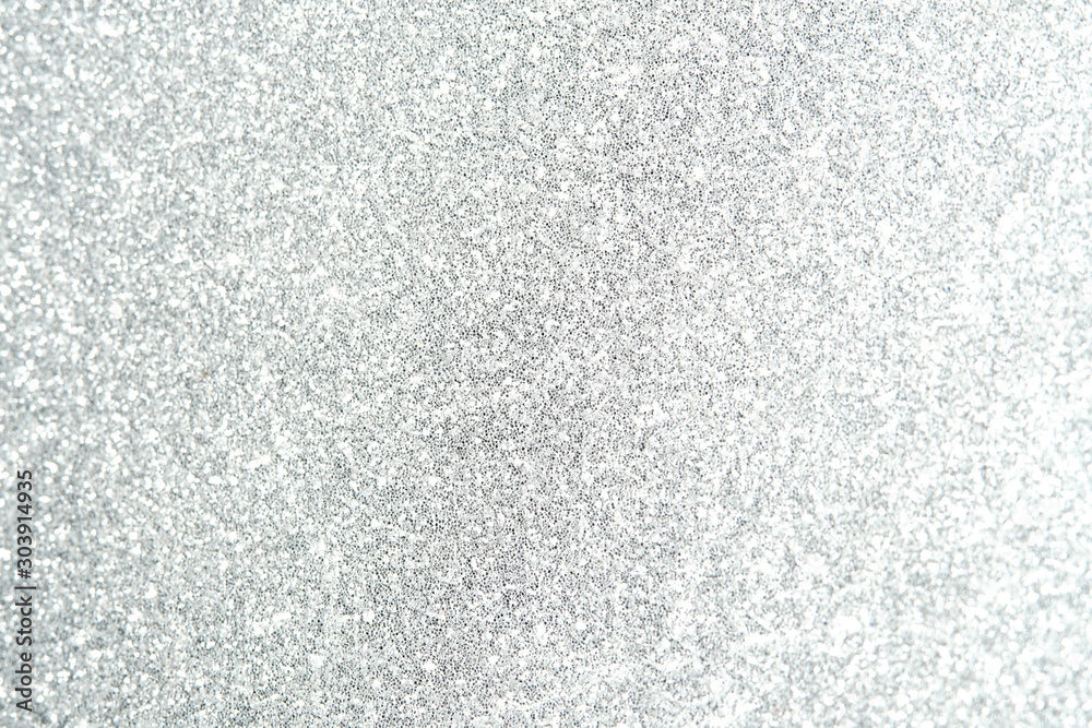 Fototapeta premium Silver Sparkling Lights Festive background with texture. Abstract Christmas twinkled bright bokeh defocused and Falling stars. Winter Card or invitation
