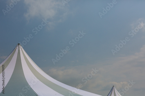 The dome of a traveling circus against the sky with clouds in a provincial town.