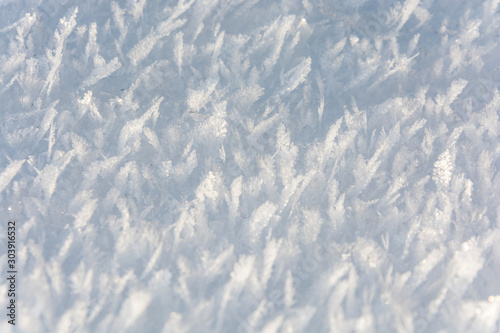 Fresh snow background. Each snowflake glitters. White snowed surface.