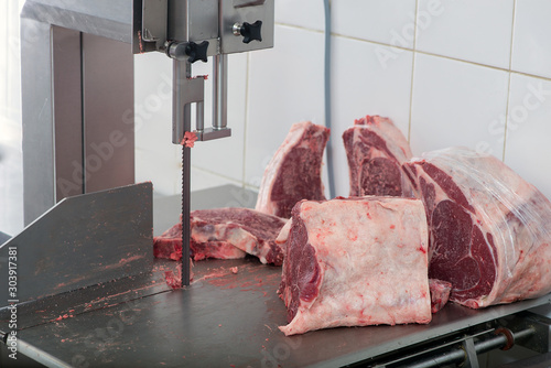 band saw cuts meat in a meat shop