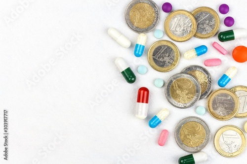Financing of health care. Medicine, finance, health care and drug trafficking - medical pills or drugs and euro coin on white background.