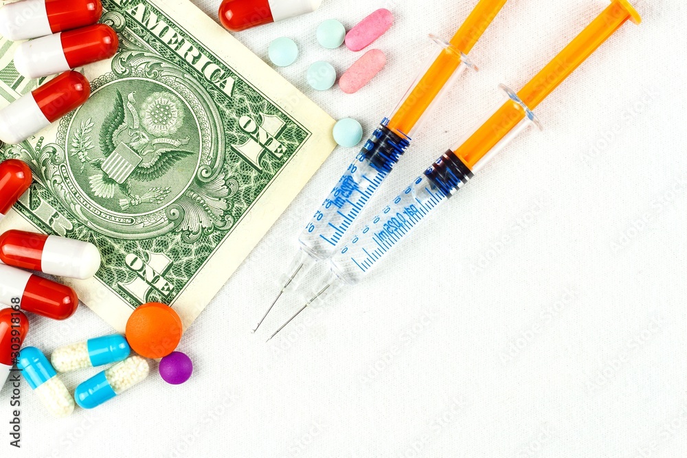 Financing of health care. Medicine, finance, health care and drug trafficking - medical pills or drugs and dollar cash money on white background. Financing of health care. Medicine, finance, health care and drug trafficking - medical pills or drugs and dollar cash money on white background.
