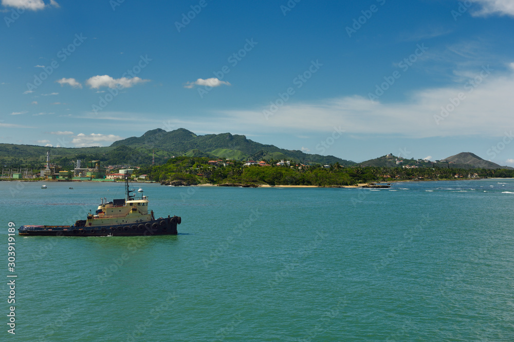 Tugboat in Puerto Plata Bay waiting for an incoming container ship on the Atlantic Ocean