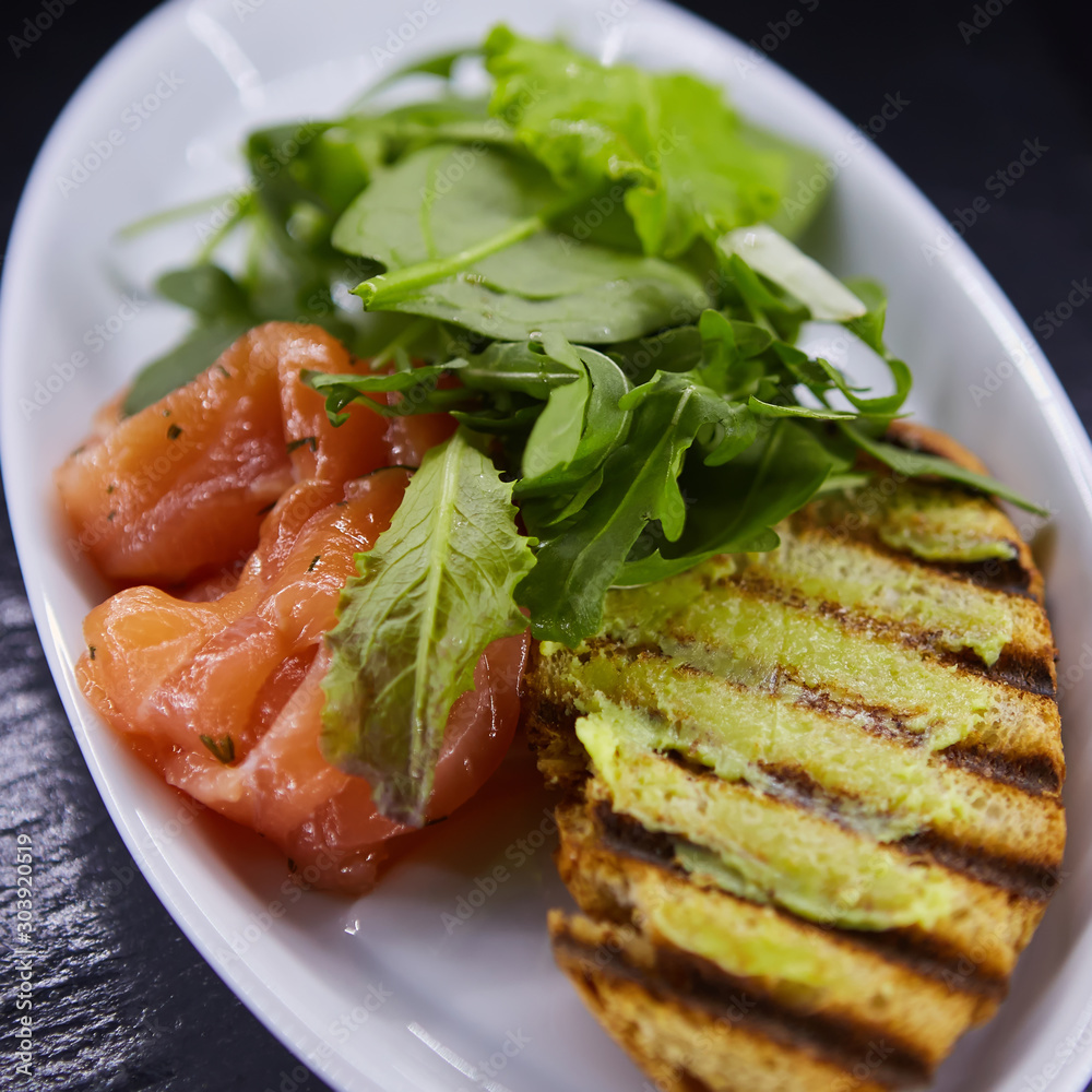 sandwich with smoked salmon, cheese, tomatoes and herbs for healthy breakfast. close up