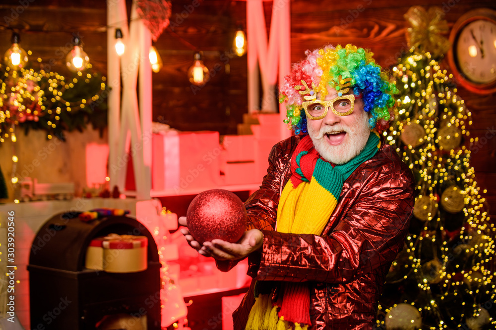 Christmas spirit. Bearded grandfather senior man celebrate christmas. Cheerful clown colorful hairstyle. Mature man with white beard. Winter holidays. Christmas decorations home. Party entertainment Christmas spirit. Bearded grandfather senior man celebrate christmas. Cheerful clown colorful hairstyle. Mature man with white beard. Winter holidays. Christmas decorations home. Party entertainment