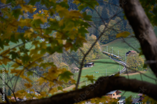 A train in the Lauterbrunnen valley seen from the Staubbachfall waterfall. Autumn in the Bernese Oberland region. Switzerland