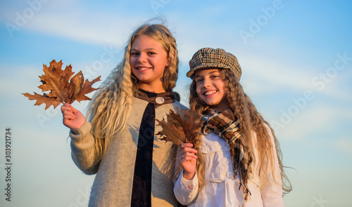 happiness. stylish sisters in fall beret. autumn trends. kid fashion look. clear sky weather. happy childhood. hairdresser salon concept. small girls with curly hair. children friends autumn leaf