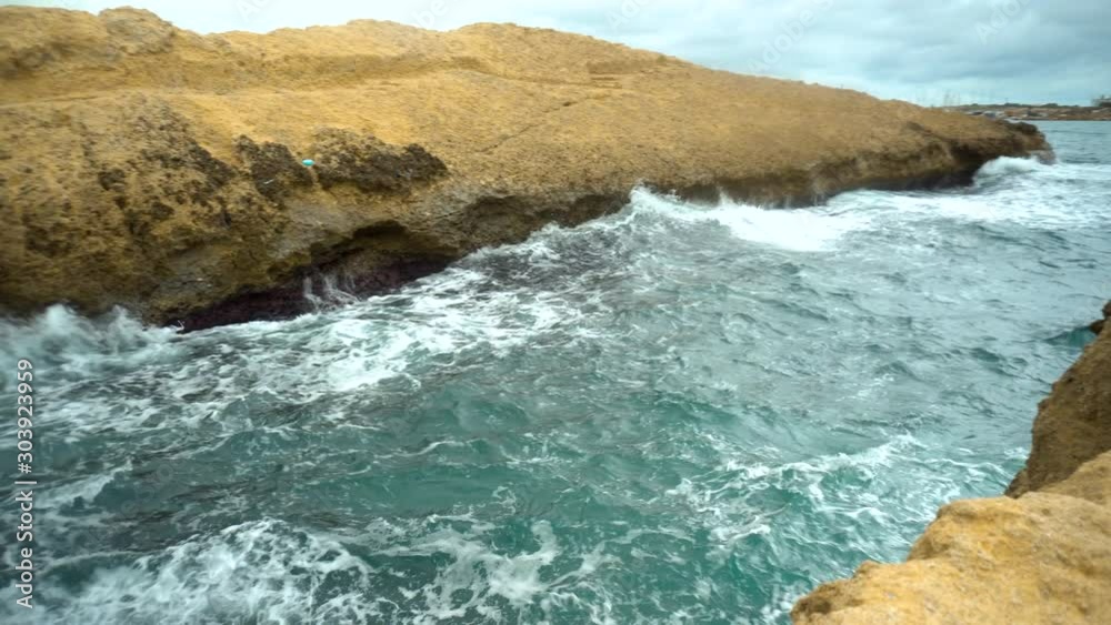 The waves beat against the rocks. Storm on the Mediterranean Sea. The sea is turquoise The waves beat against the rocks. Storm on the Mediterranean Sea. The sea is turquoise