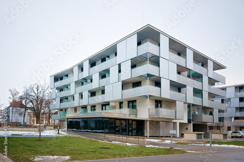 Modern residential apartment and flat buildings exterior in Salzburg, in Austria. New luxury house and home complex. City Real estate property and condo architecture. Snow in the street on background