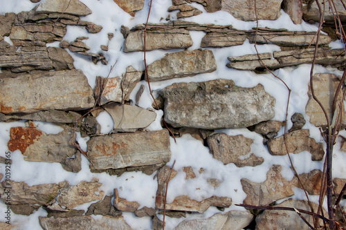Wall made of natural rocks covered in snow