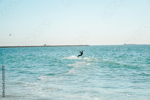 Professional kiter rides on the waves, jumps on the sea. © Nataly
