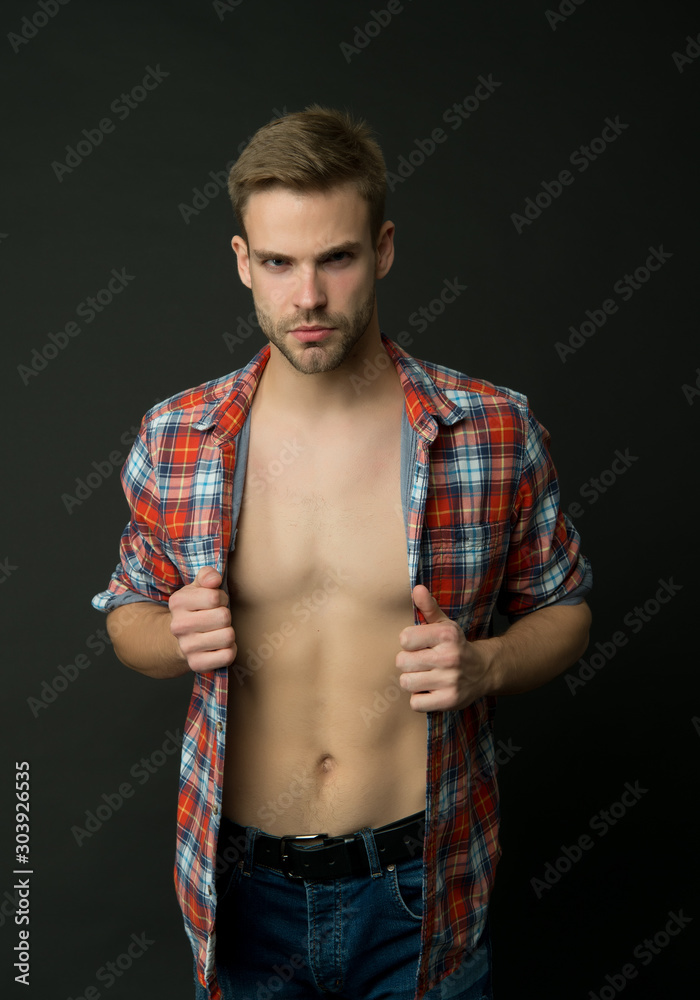 Sexy muscular macho. Athlete man undressing. Muscular guy. Attractive man  confident face taking off shirt. Perfect body. Muscular torso six packs.  Masculine traits concept. Male fashion and beauty foto de Stock