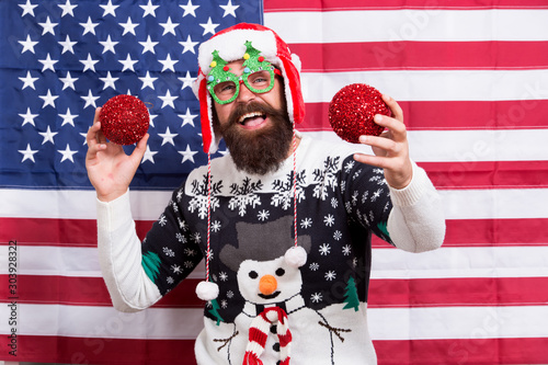 Happy new year. Happy santa celebrate xmas and new year. Bearded man happy smiling on american flag background. Happy holidays. Merry Christmas. Holiday season in USA © be free